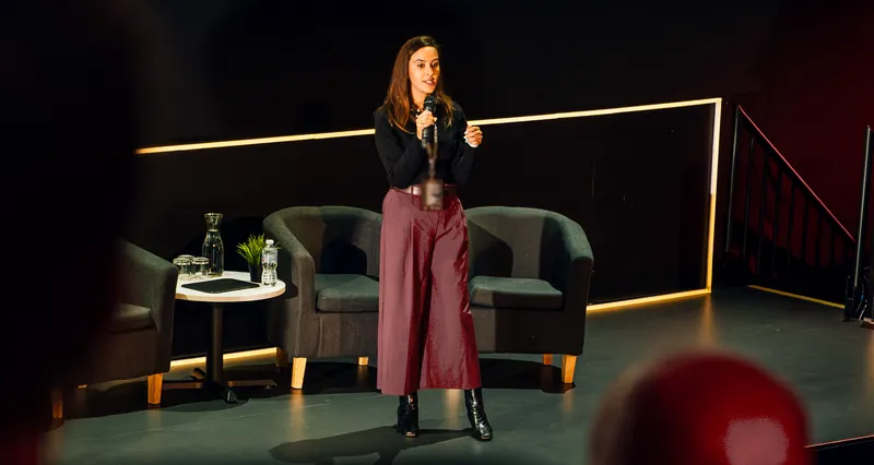 Sharon Dhillon on stage, speaking to an audience of business owners and buyers in Birmingham